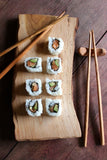 Wooden chopsticks and sushi serving plank